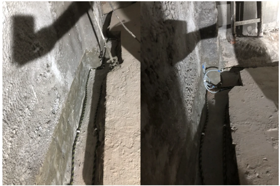 Dy pamje të tubave fleksibël të injektimit të vendosur pranë murit në brezin e ekspozuar të dyshemesë; djathtas duken skajet e nxjerra të tubave.